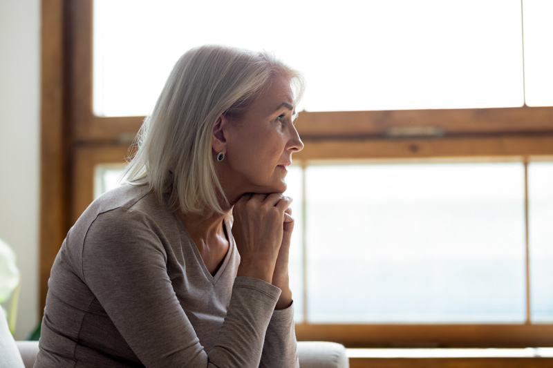 Mujer reflexionando sobre su pensión de viudedad