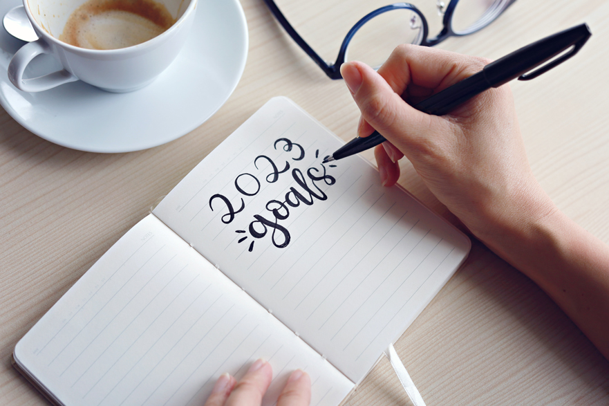 Trabajadora escribiendo sus metas profesionales para 2023