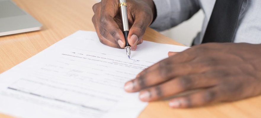Trabajador firmando el documento de finiquito tras ser despedido