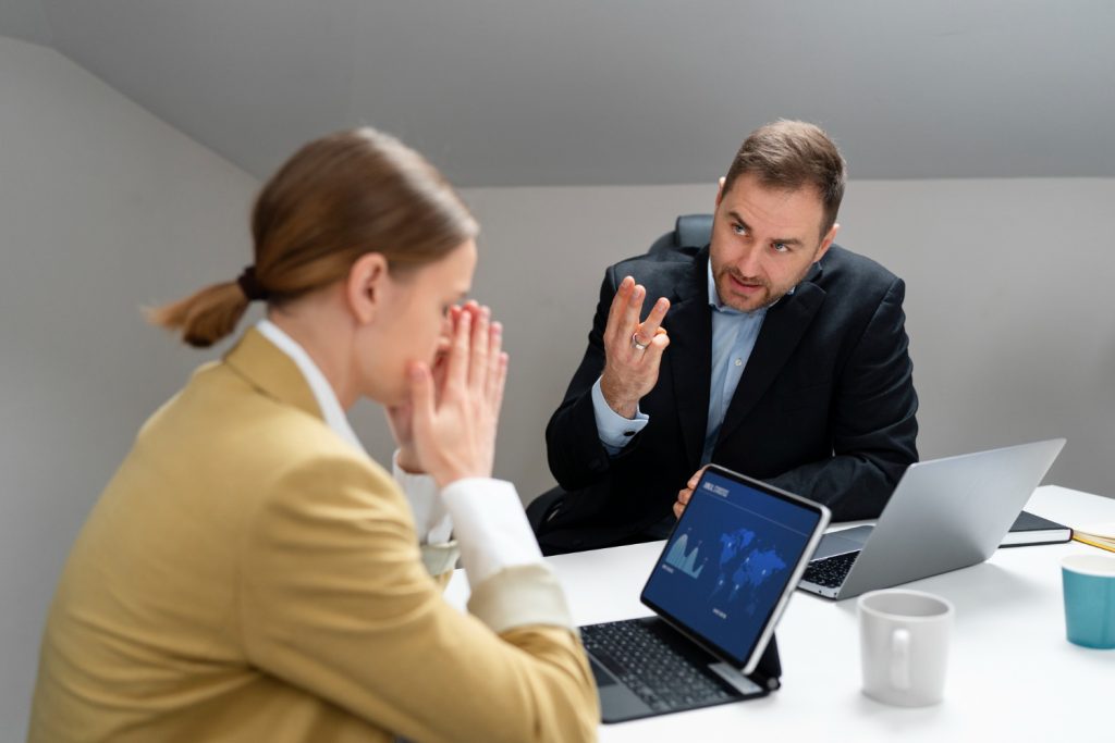 Empleada enfrentando críticas en el trabajo por parte de su jefe