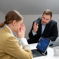 Empleada enfrentando críticas en el trabajo por parte de su jefe