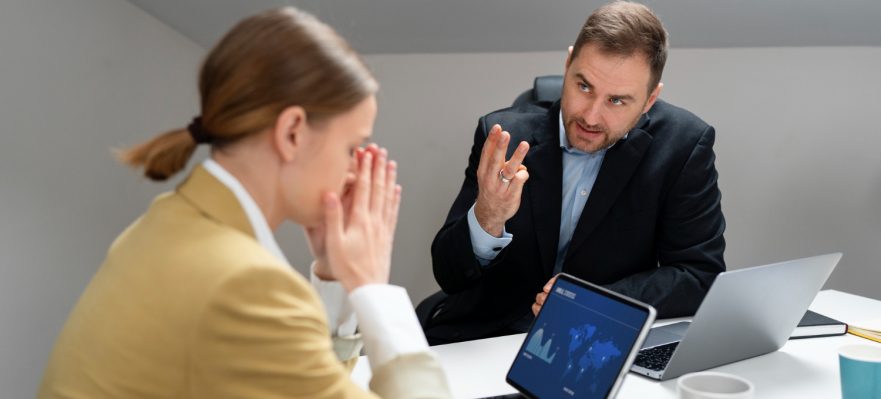 Empleada enfrentando críticas en el trabajo por parte de su jefe