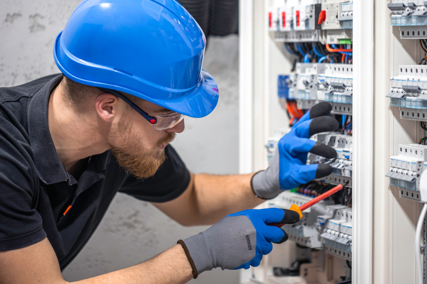 Electricista trabajando en un cuadro eléctrico con un cable de conexión. Magnific